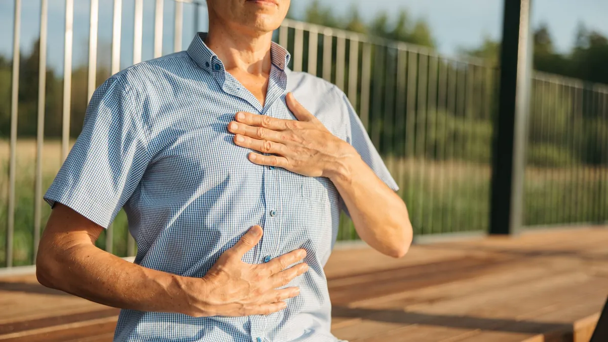 A man breathing slowly with one hand on his chest and one on his abdomen
