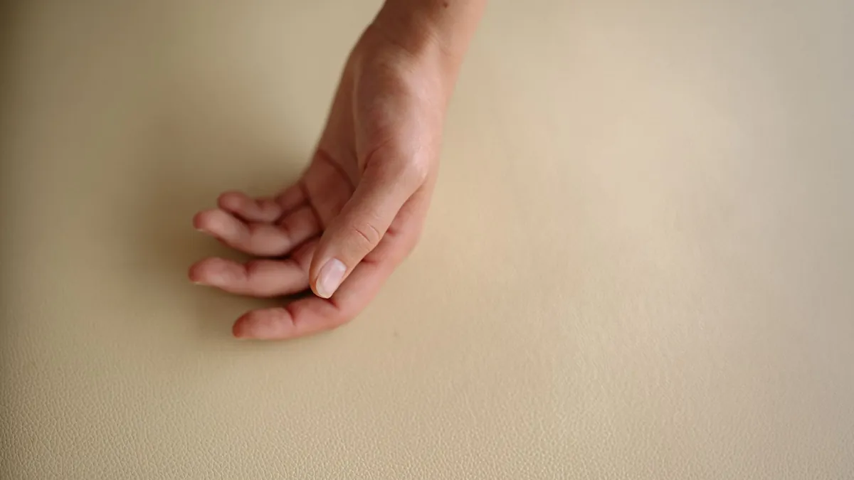 A relaxed hand resting on a softly textured surface