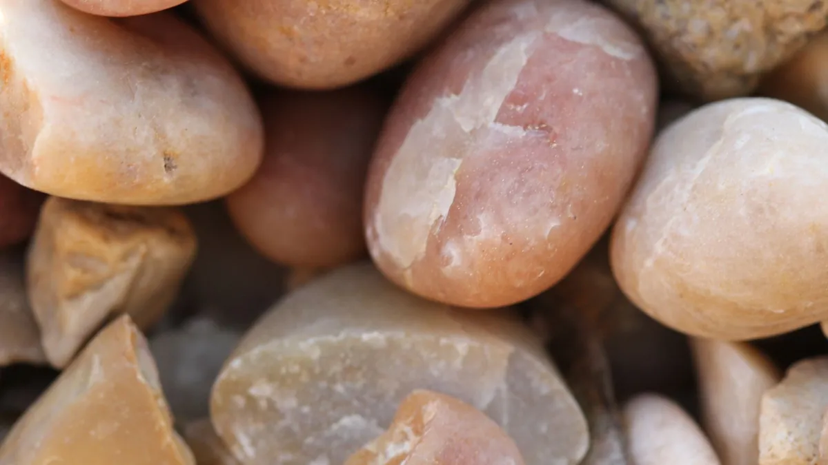 Macro photograph of smooth warm-toned pebbles showing their texture